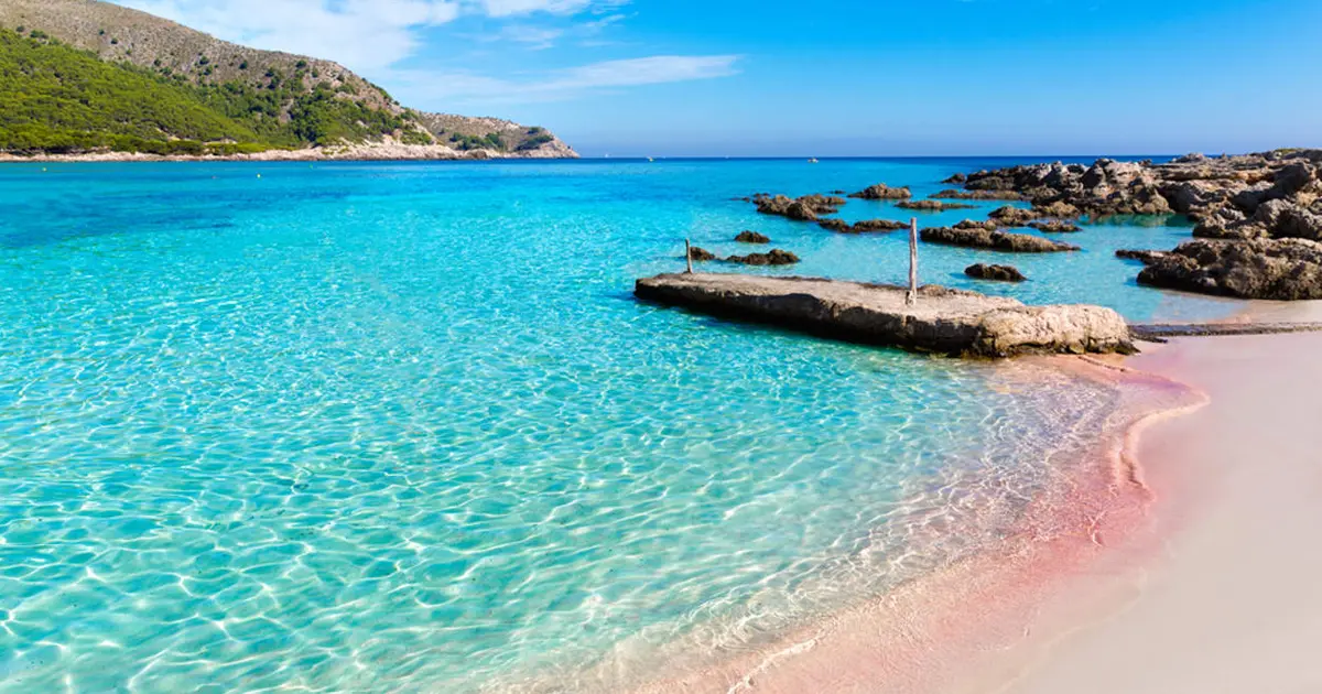 Aguas cristalinas y fondo de arena clara en la bahía natural de Cala Agulla