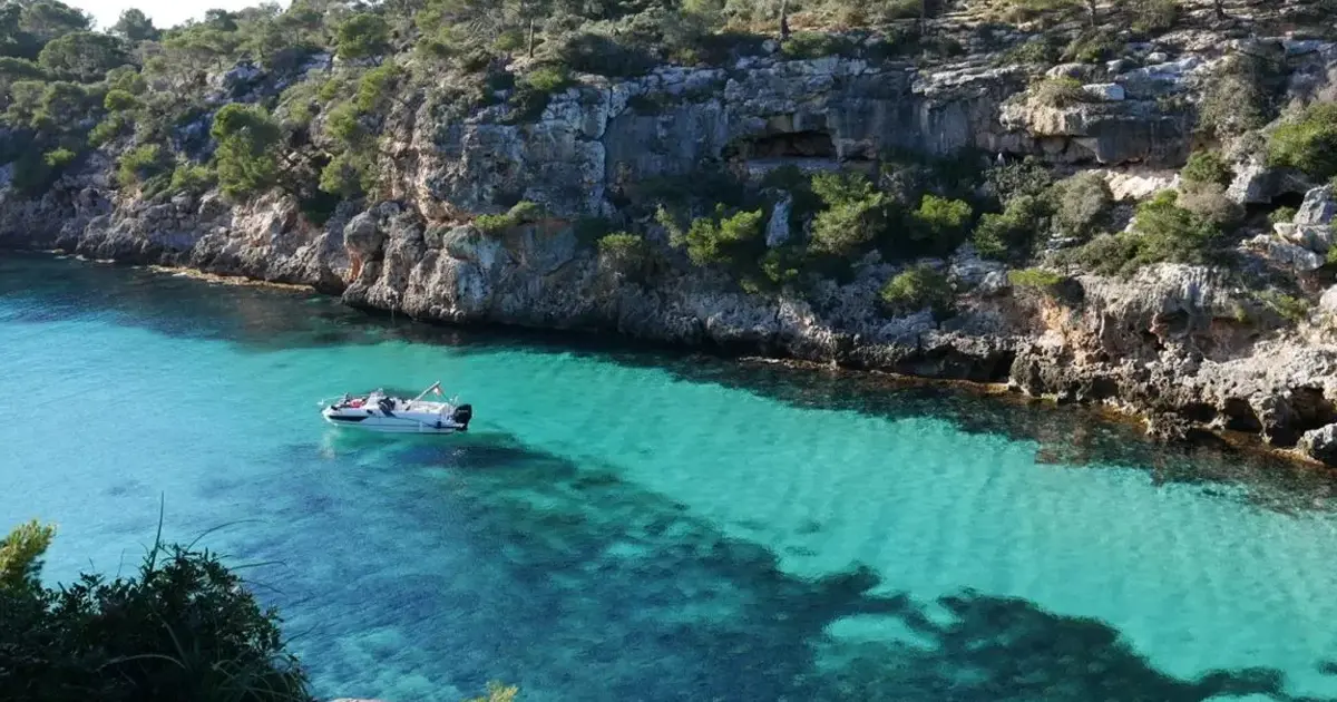 Vista desde las alturas de la cala de aguas turquesas entre altos acantilados en Cala Pi
