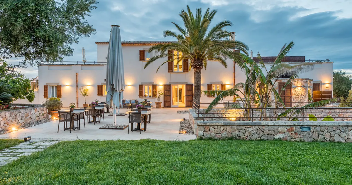 Terraza exterior iluminada al atardecer en el agroturismo solo adultos Cas Cabo Nou