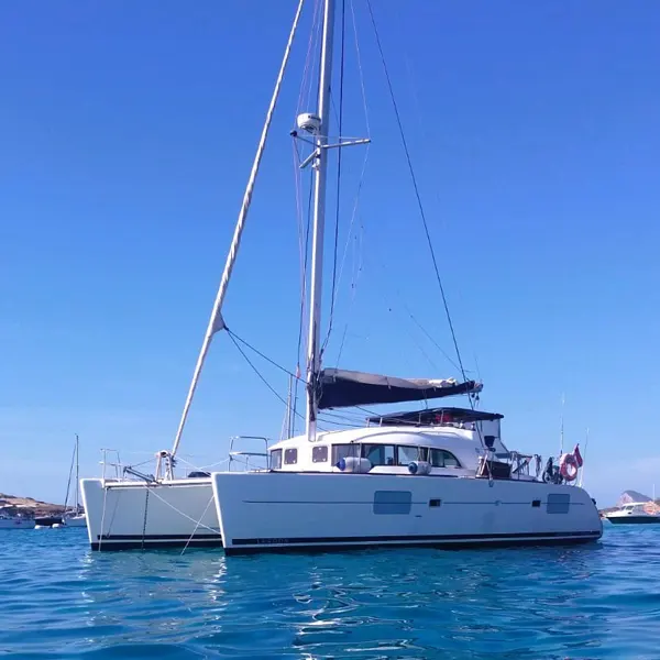 Catamarán blanco navegando por las aguas turquesas del norte de Mallorca