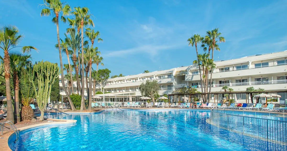 Piscina exterior rodeada de palmeras en el hotel familiar Fergus Club Palmanova Park
