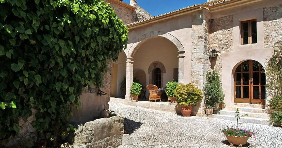Patio interior mallorquín con arcos de piedra en Finca Hotel Son Palou Orient