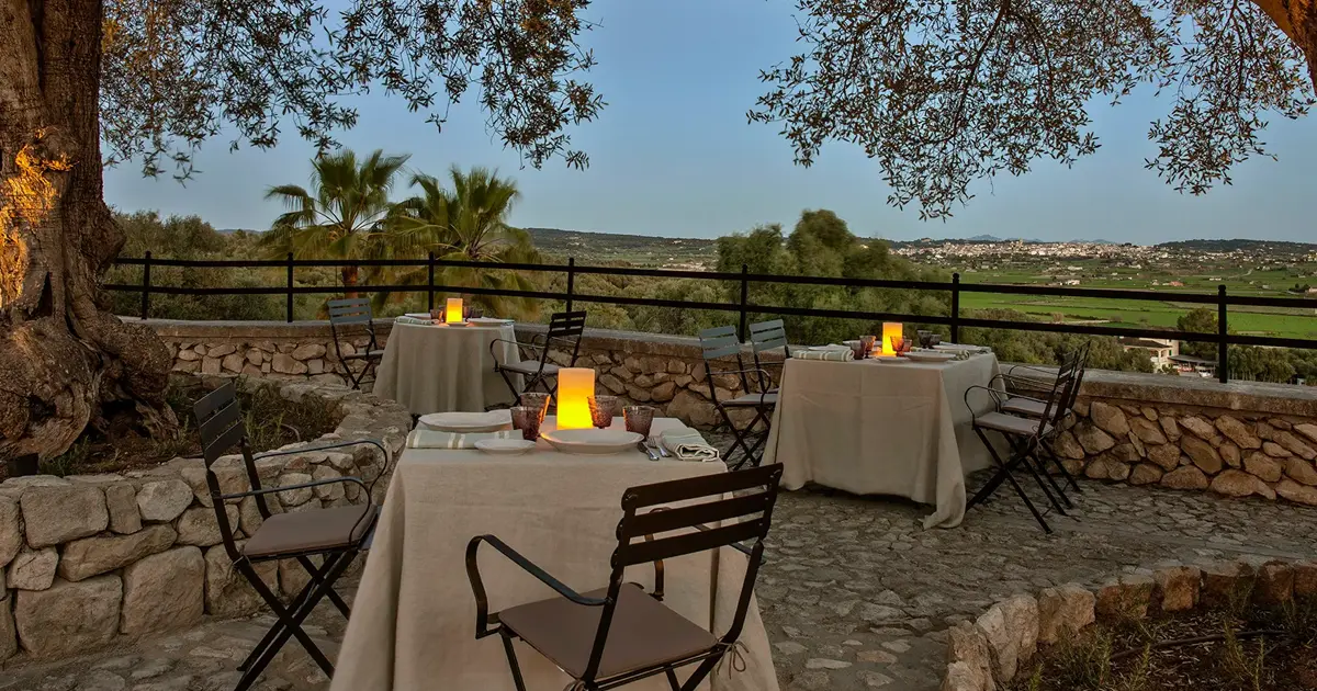 Terraza del restaurante exterior en Finca Serena Mallorca con mesas vestidas y vistas a los campos de Montuiri