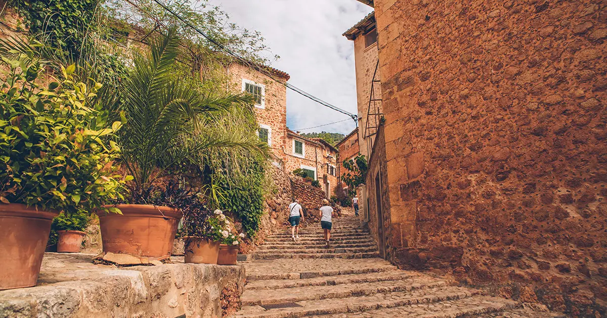 Calles empedradas escalonadas con flores en el pueblo de Fornalutx