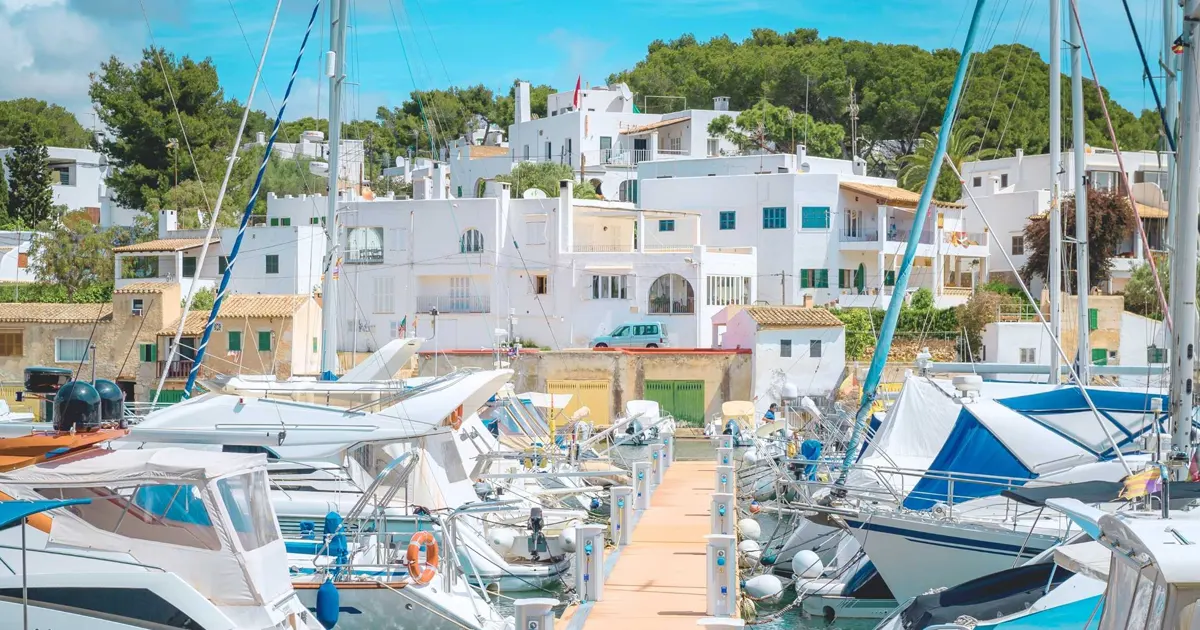 Casas blancas de estilo ibicenco y cala de aguas turquesas en Cala d'Or Mallorca