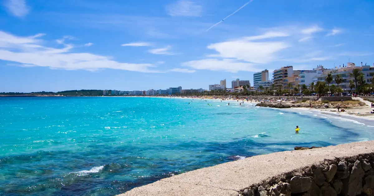 Extensa playa de arena fina y paseo marítimo de Cala Millor en el levante de Mallorca