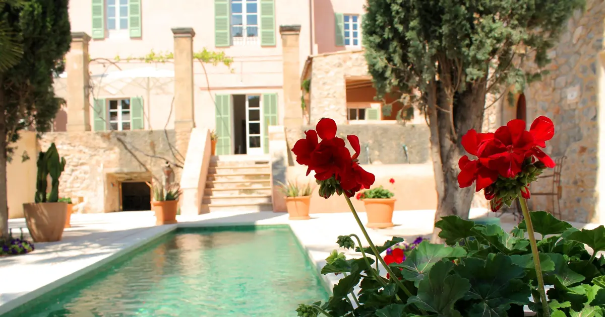 Patio interior con piscina y flores rojas en Yartan Boutique Hotel en Arta